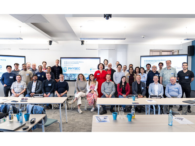 Es handelt sich um ein Gruppenfoto. Darauf sind die Besuchenden des "6th Management Committee Meeting" und "4th Working Group Meeting" zu sehen.