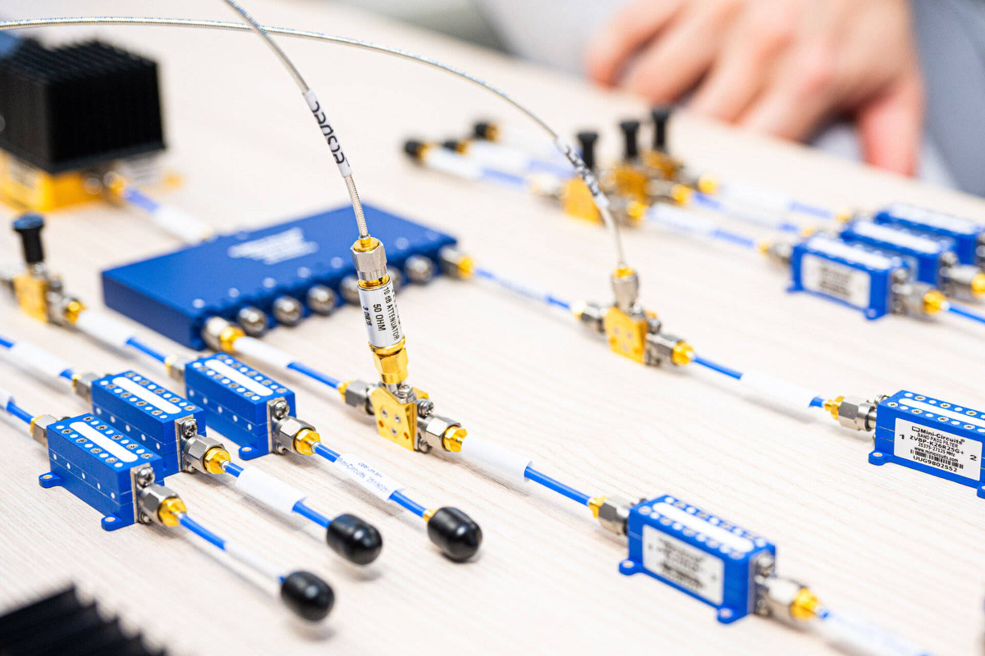 Mehrere blaue elektronische Messgeräte mit Kabeln und Steckverbindern auf einem hellen Tisch