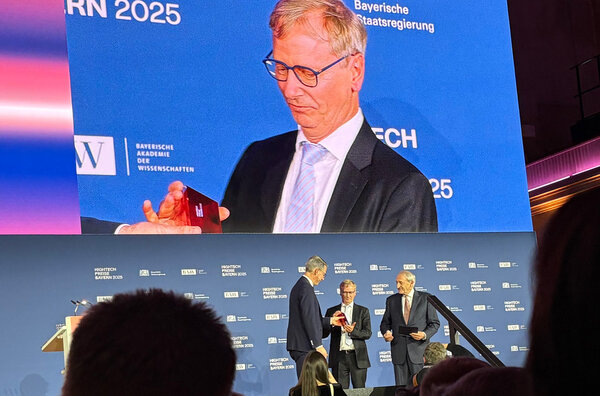 The 3 men on stage. Gerhard Fettweis receives a red prize.