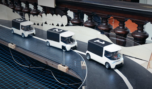 three numbered cars drive in convoy around a curve
