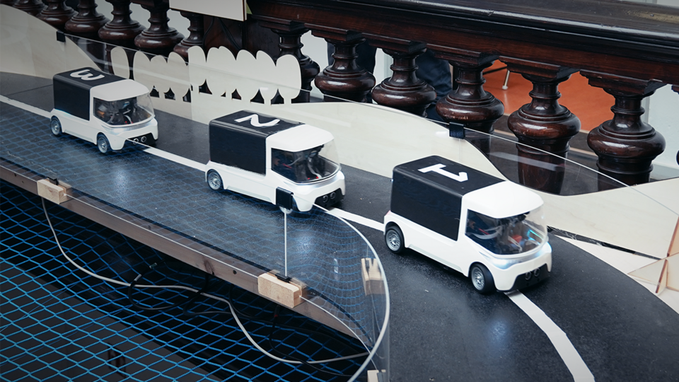 three numbered cars drive in convoy around a curve