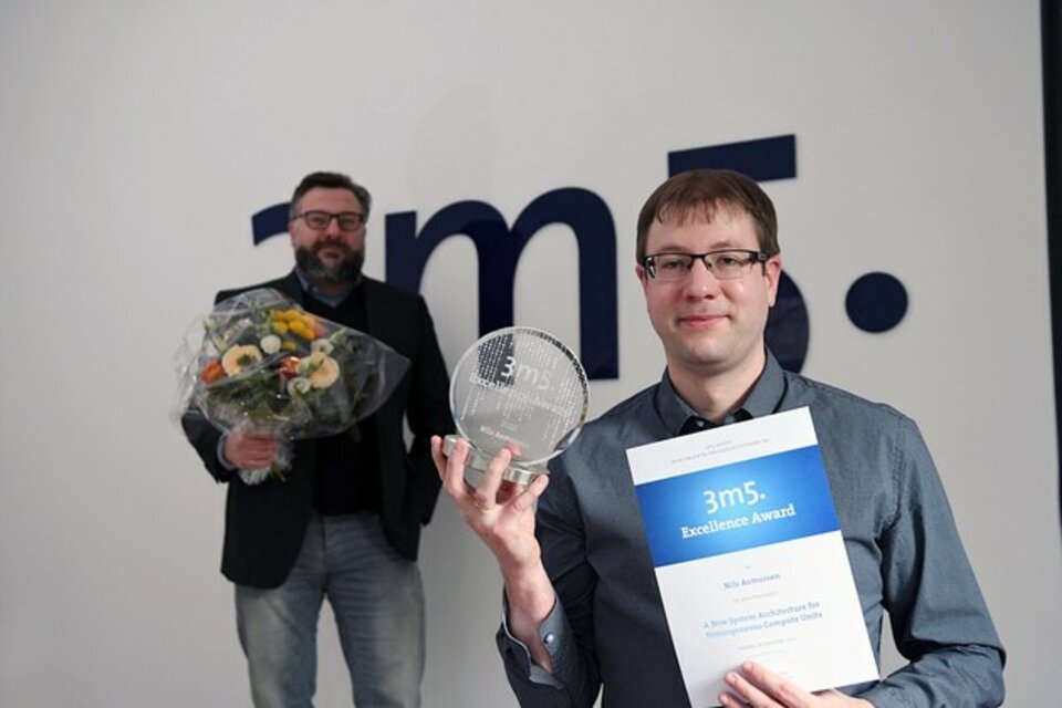 Nils Asmussen holding the award for his dissertation
