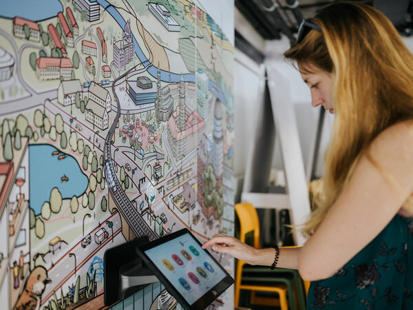 A woman interacts with the exhibit of a panorama on the topic “Internet of Things”.