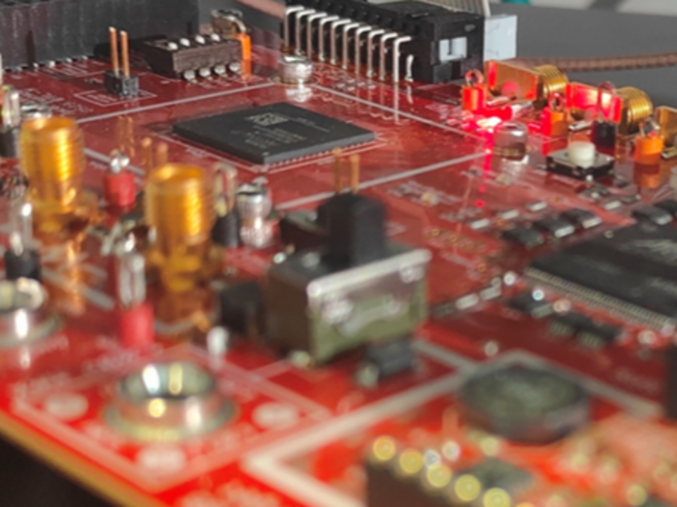 Close-up of a red circuit board with various electronic components and glowing red LEDs