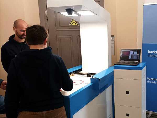 Ein Kind spielt gegen den Airhockey-Roboter