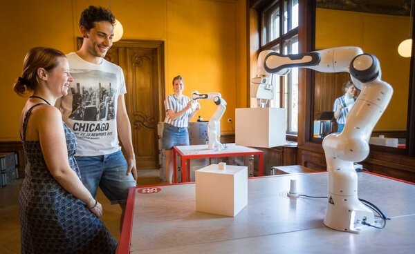 5G-Industrie-Roboter Leute in Interaktion mit dem 5G Roboter Arm