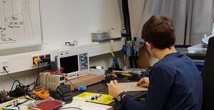 ein Junge sitzt an der Robotics Werkbank
