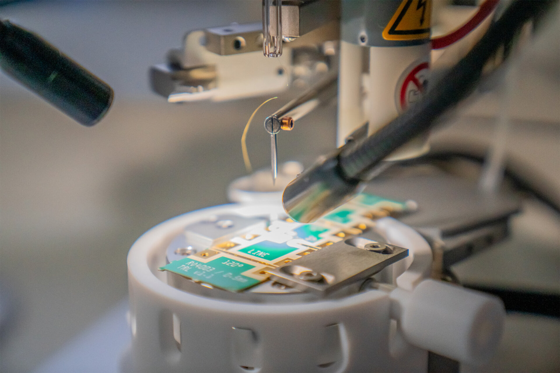 Close-up of a precision machine with a needle and electronic components on a circular platform