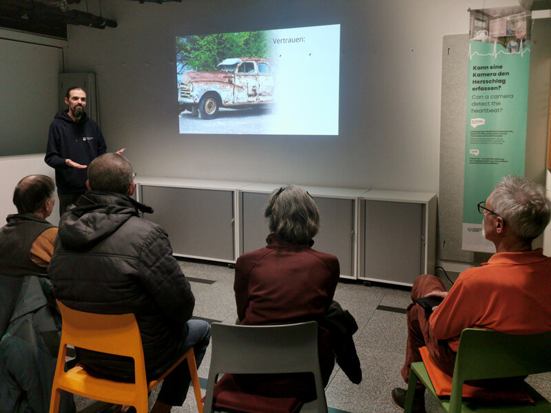 A Man presents on the topic of trustworthiness in front of a group of people