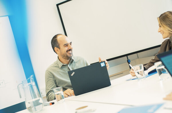 People sitting at a table, smiling at each other