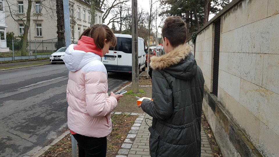 two people on the street measuring fine dust