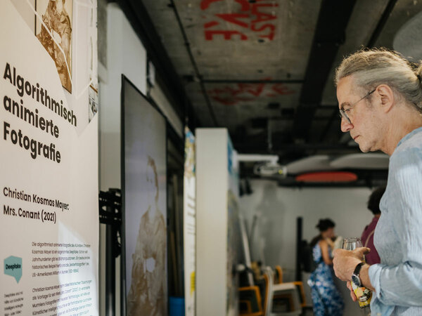 A man reads through the exhibition text on algorithmically animated photography