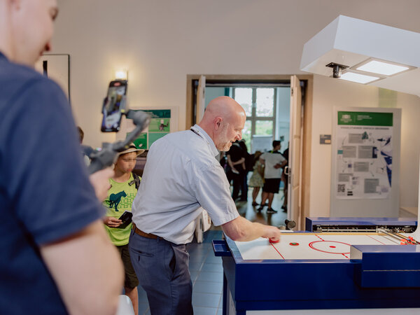 Ein Mann spielt Air-Hockey gegen einen Roboter in der Maschine