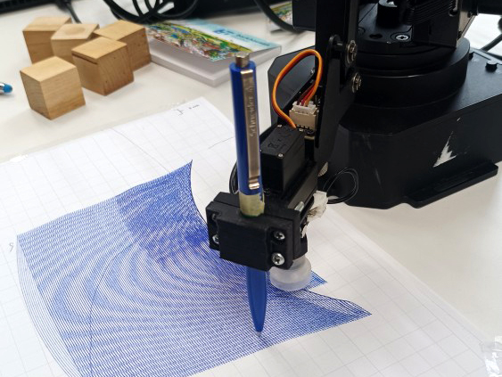 A robot arm is drawing a pattern with a pen