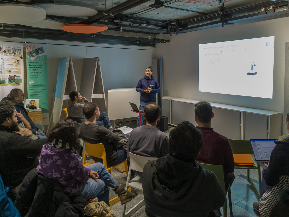 A man presenting in front of a group of people sitting on chairs